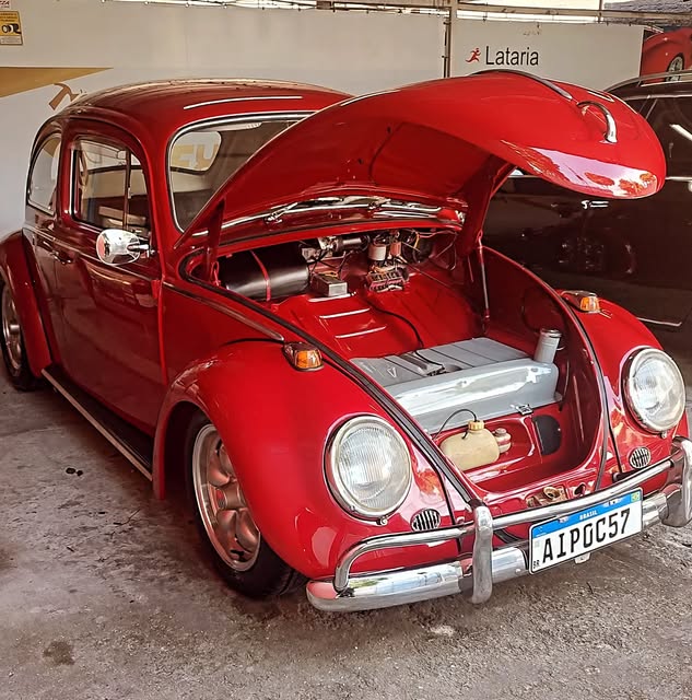 Fusca vermelho clássico com o motor aberto para revisão